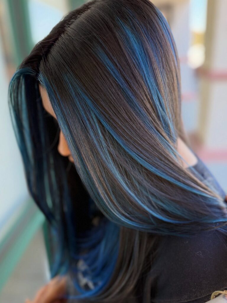 Long black hair with thick, vibrant blue vertical highlights throughout the strands.