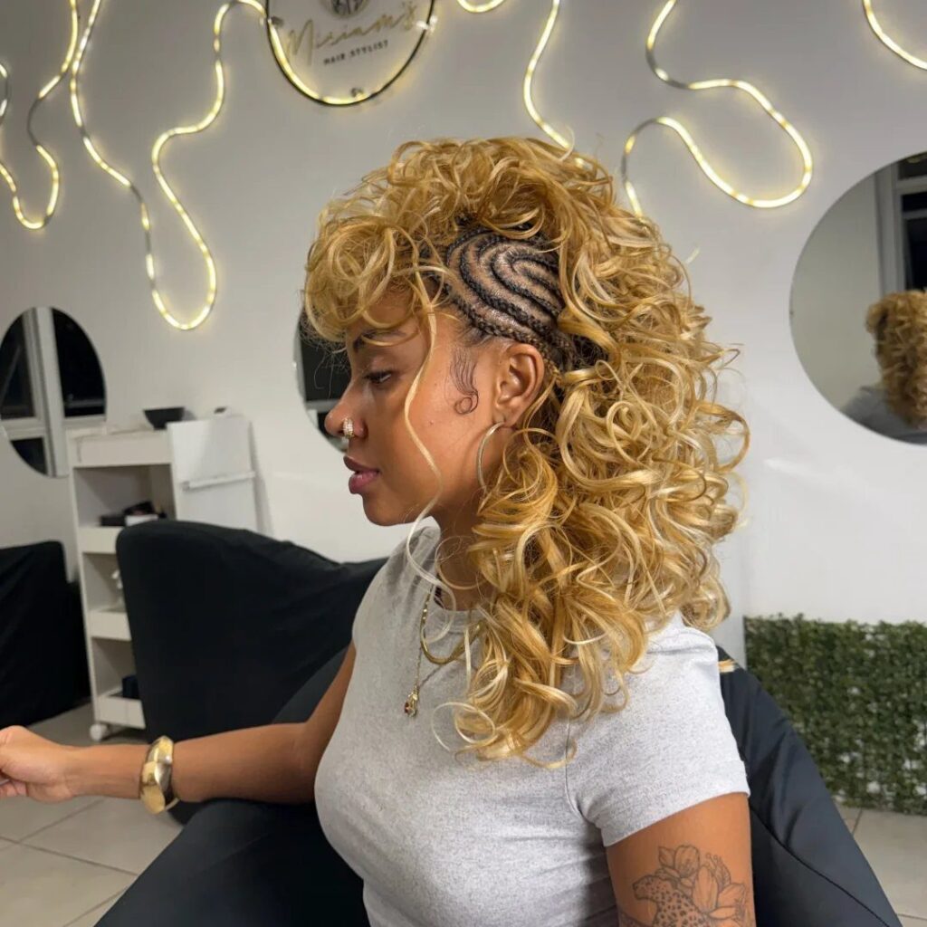 Woman with blonde curly mohawk hairstyle and braided sides in a hair salon.