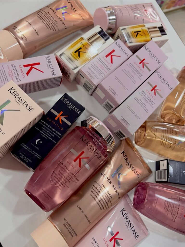 Kérastase hair care bottles and boxes in pink and gold on white background