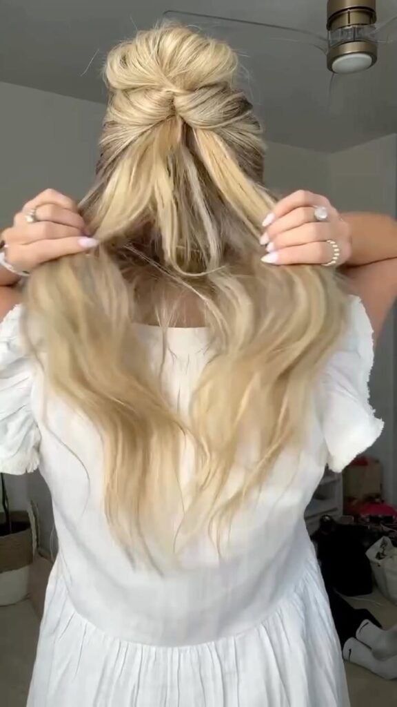 Blonde hair styled in a half-up top knot bun on a woman.