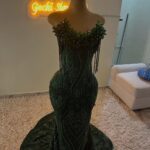 Dark green sequined mermaid dress with beaded neckline on a mannequin