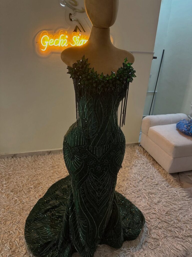 Dark green sequined mermaid dress with beaded neckline on a mannequin